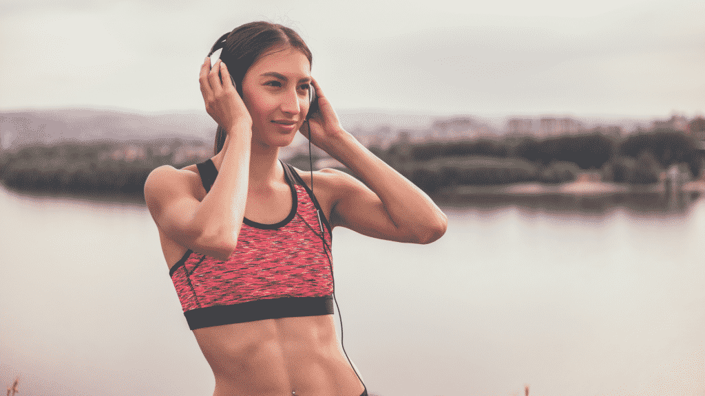 Mulher praticando exercício e ouvindo música com fones de ouvido