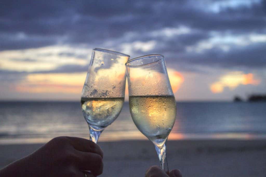 Duas pessoas brindando uma taça de champagne.