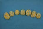 Pedras amarelas com letras que representam a palavra saudade.