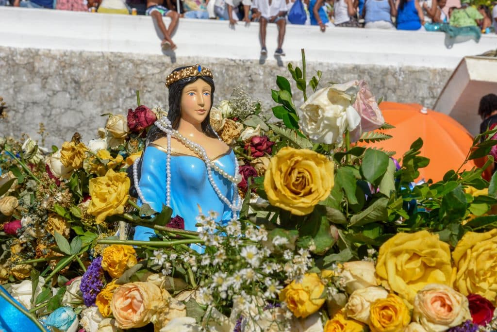 Uma estátua de Iemanjá com rosas cercando-a.