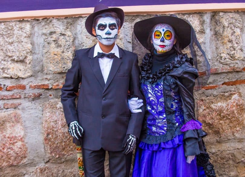 Um homem e uma mulher fantasiados para o Día de Los Muertos.