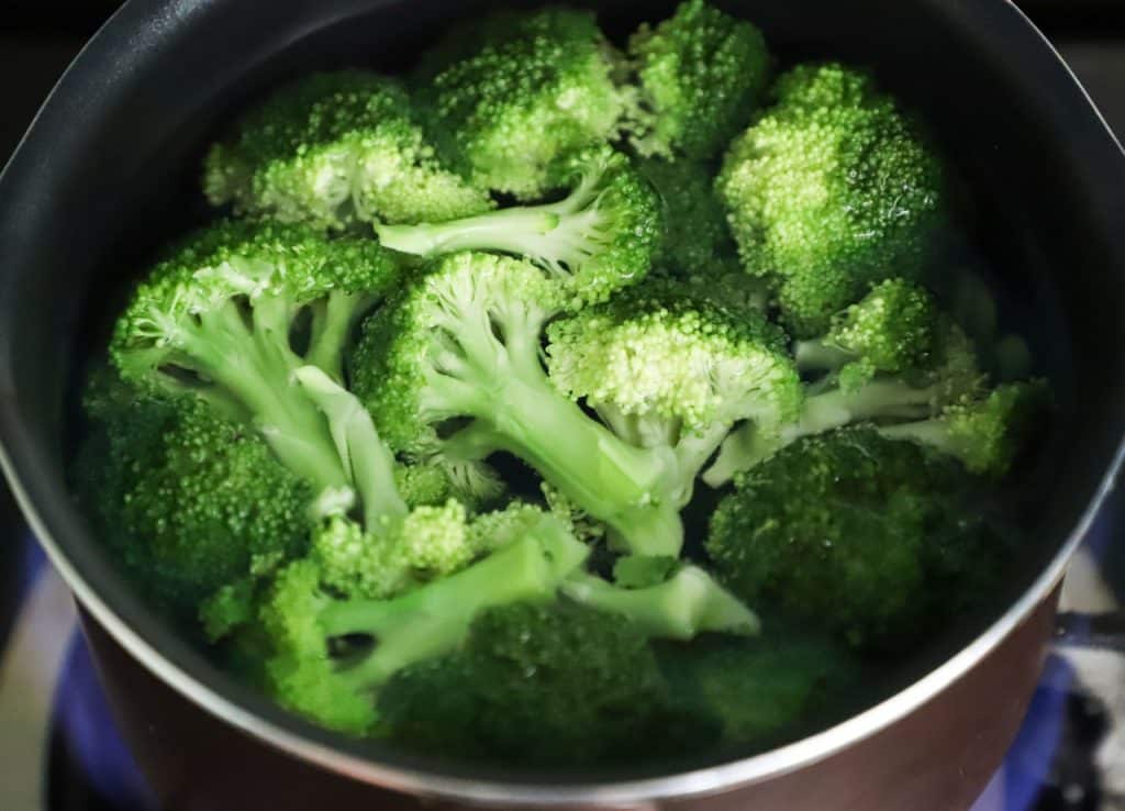 Brócolis cozidos em uma panela.