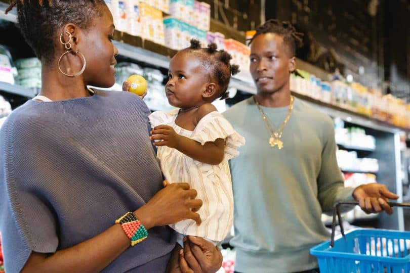 Mãe e pais com a filha no mercado