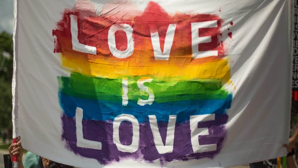 Bandeira LGBT com o escrito "Love is Love"