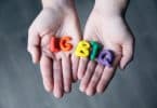 Mãos segurando letras feitas de massinha formando a sigla LGBT
