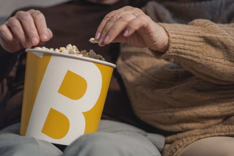 Um casal assistindo filme e comendo pipoca juntos