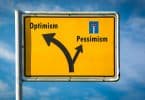 Uma placa com os seguintes elementos gráfico-visuais: 'pessimism' à esquerda, com uma seta à esquerda; com uma seta à direita, 'otimism'.