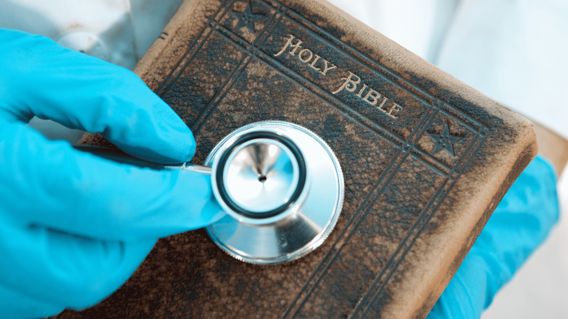 Pessoa com estetoscópio sob a bíblia 