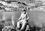 Imagem do filósofo Peter Deunov sentado na beira de um rio