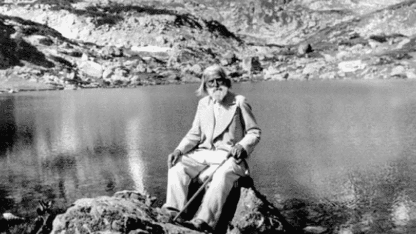 Imagem do filósofo Peter Deunov sentado na beira de um rio
