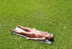 Mulher deitada na grama.