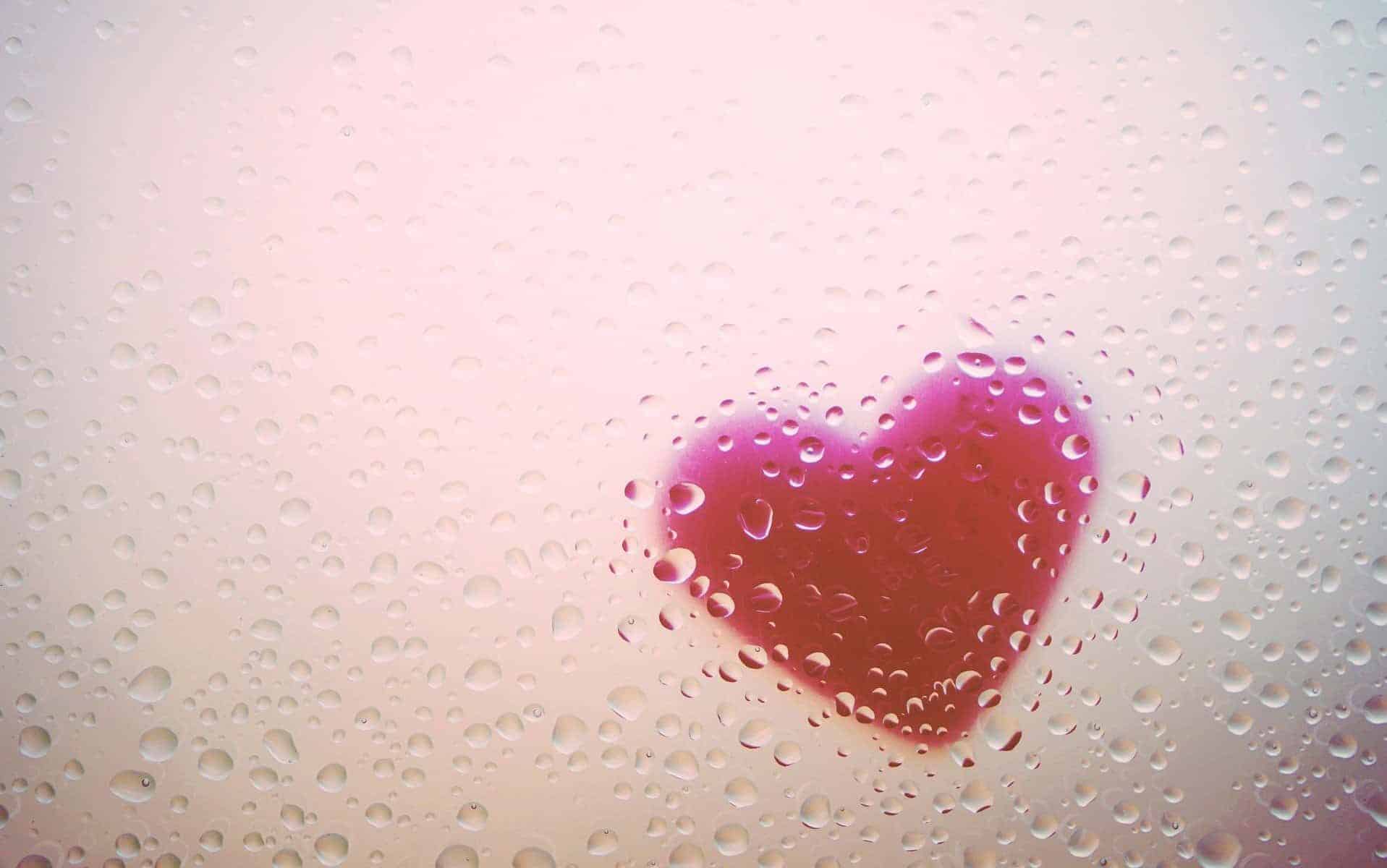 Uma representação de um coração em plástico cercada de pingos d'água.