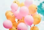 Balões coloridos com rostos felizes desenhados.