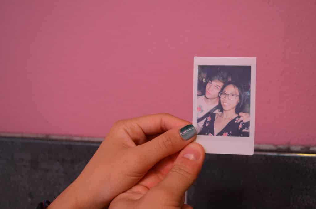 Pessoas brancas segurando foto instantânea.