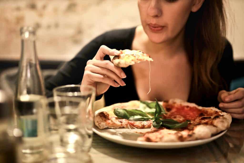 Mulher comendo pizza