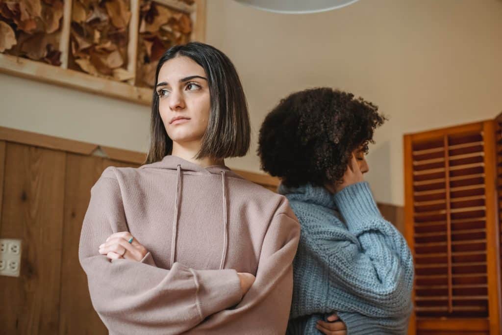 Duas mulheres desconfiadas uma de costas para a outra