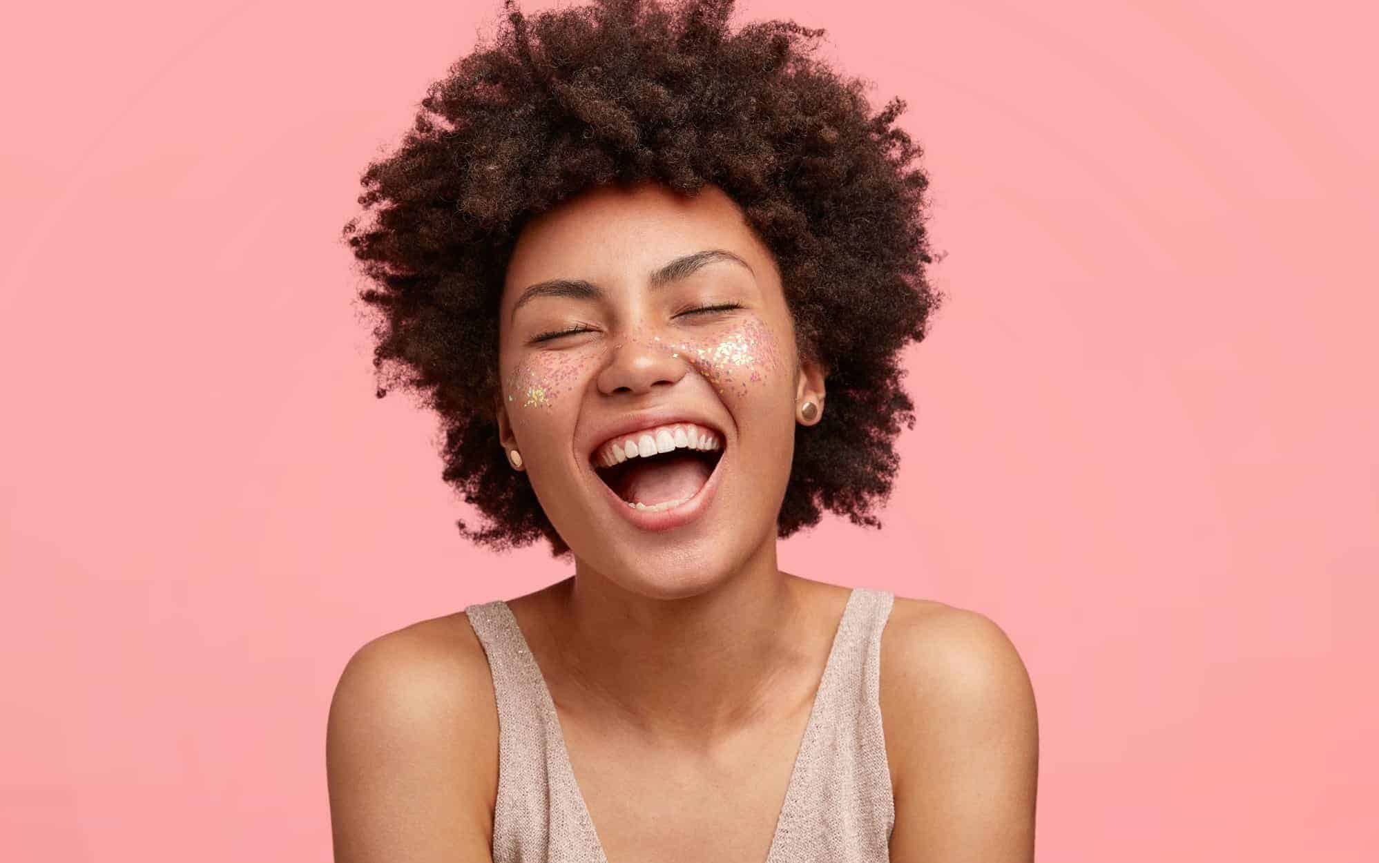 Uma mulher negra sorrindo.