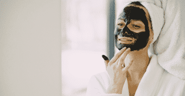 Mulher fazendo skin care com máscara de carvão