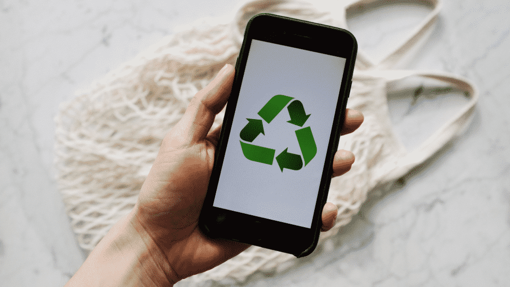 Pessoa segurando celular com o símbolo de reciclagem