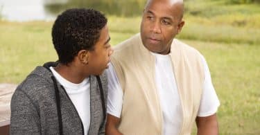 Homem e menino negros conversando.