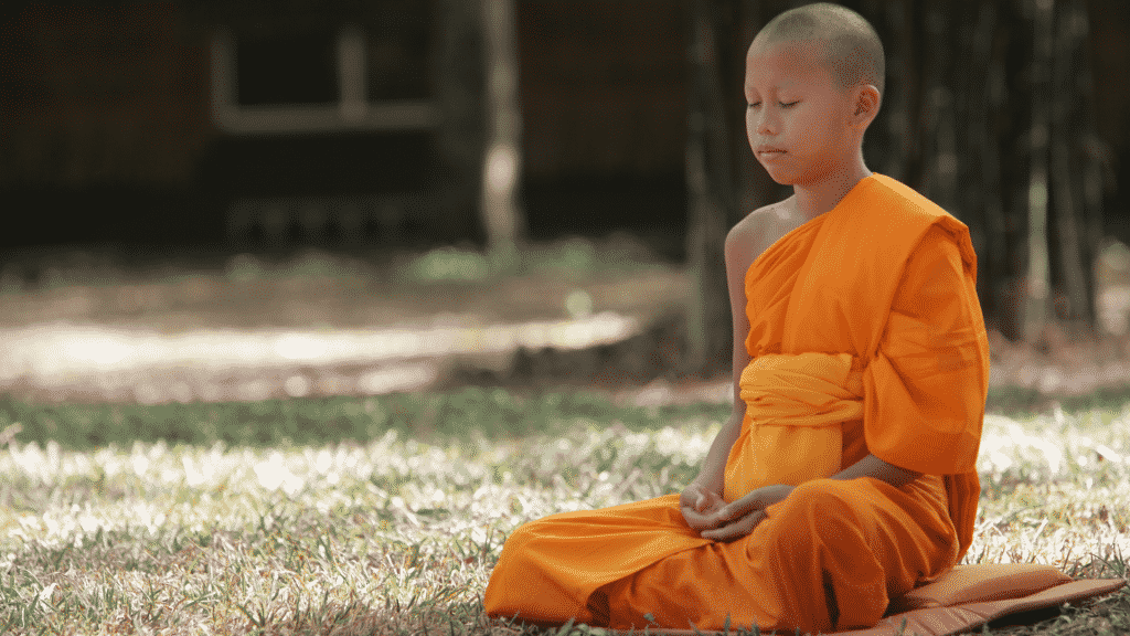 Menino budista meditando em um templo