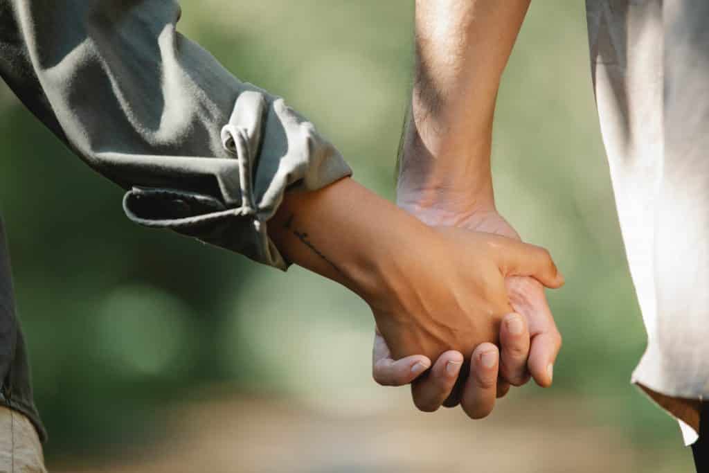 Duas mãos - de pessoas diferentes -entrelaçadas.