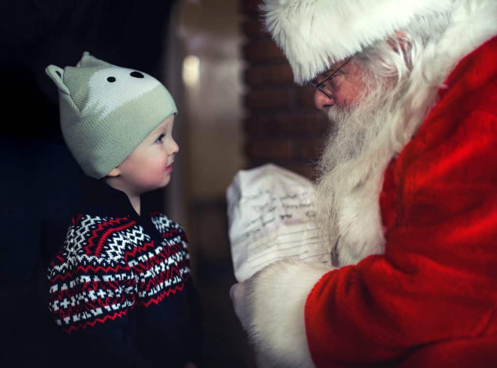 Bebê branco em frente de papai noel.