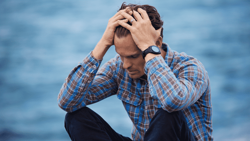 homem estressado com as mãos na cabeça