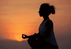 Mulher meditando durante o por do sol