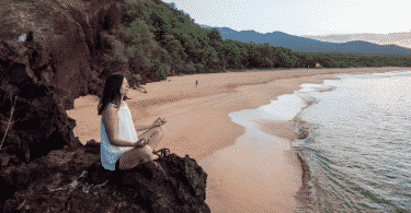 Mulher meditando na praia