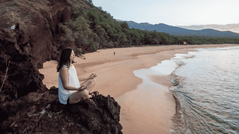 Mulher meditando na praia