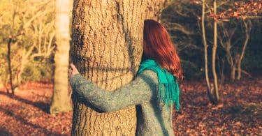 Mulher abraçando uma árvore.