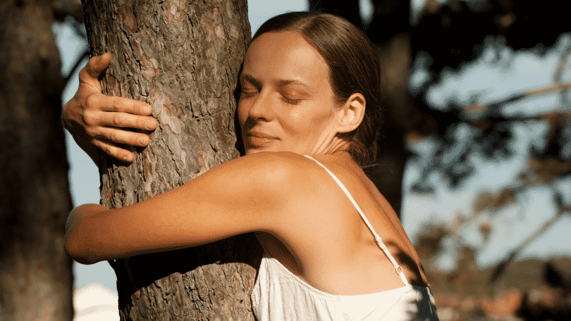 Mulher abraçando uma árvore