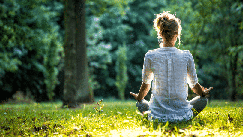 Mulher no parque meditando