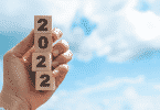 Imagem de uma mão segurando quadrados com números, formando o número 2022
