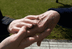 Pessoa mais jovem segurando a mão de uma pessoa mais velha