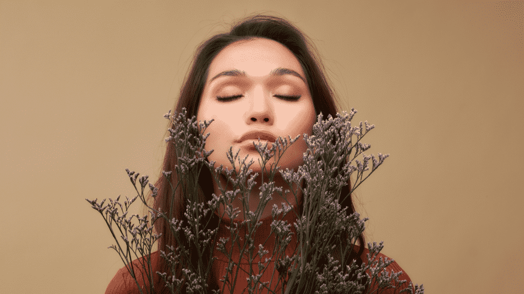 Mulher cheirando um ramo de flores de lavanda