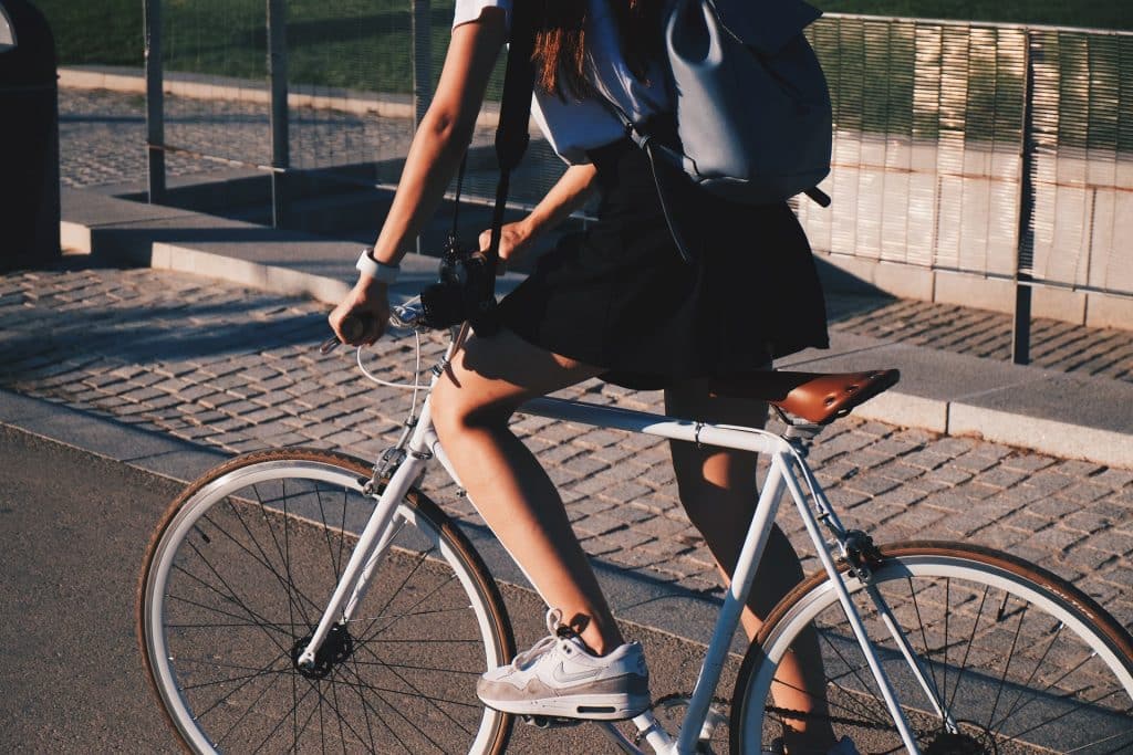 Jovem branca numa bicicleta.