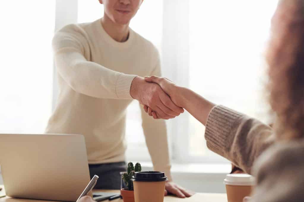 Duas pessoas apertando as mãos fechando negócios