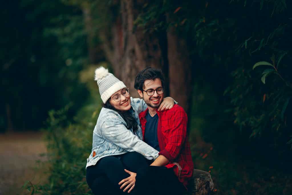 Homem e mulher sorrindo ao lado de árvores