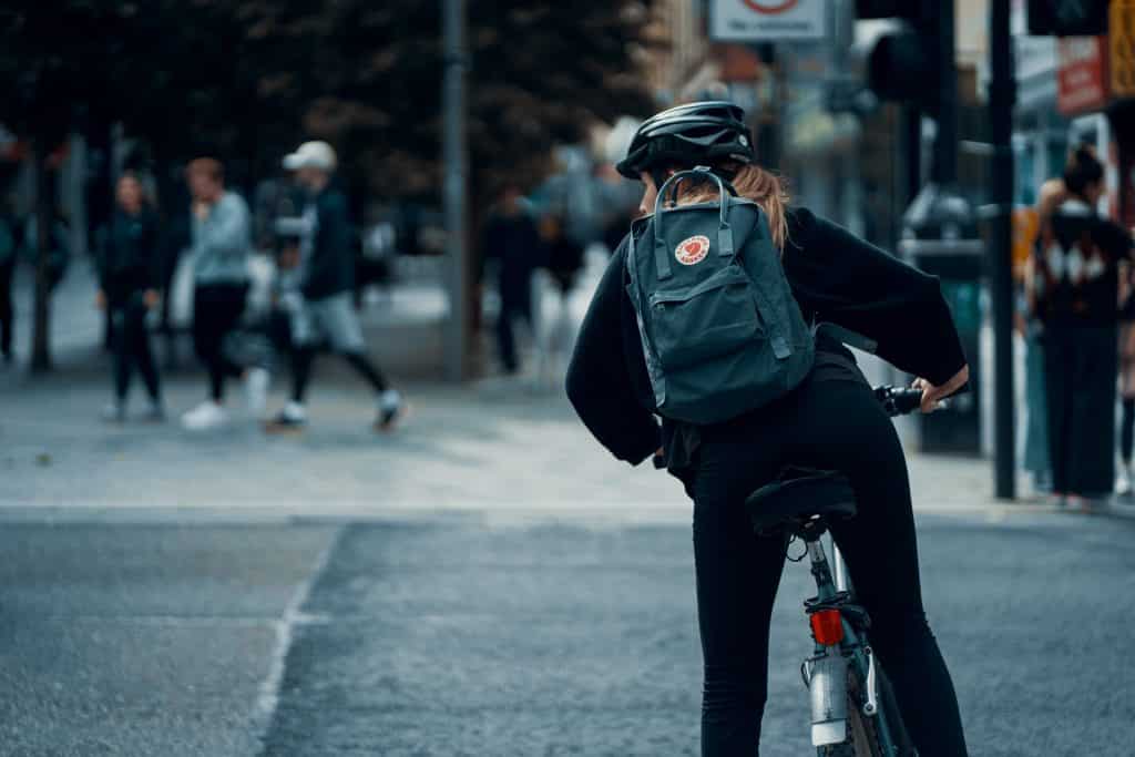 Mulher branca numa bicicleta.