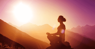 Mulher meditando durante o por do sol