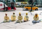 Pessoas do movimento Falung Gong sentados em meditação.