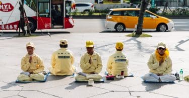 Pessoas do movimento Falung Gong sentados em meditação.