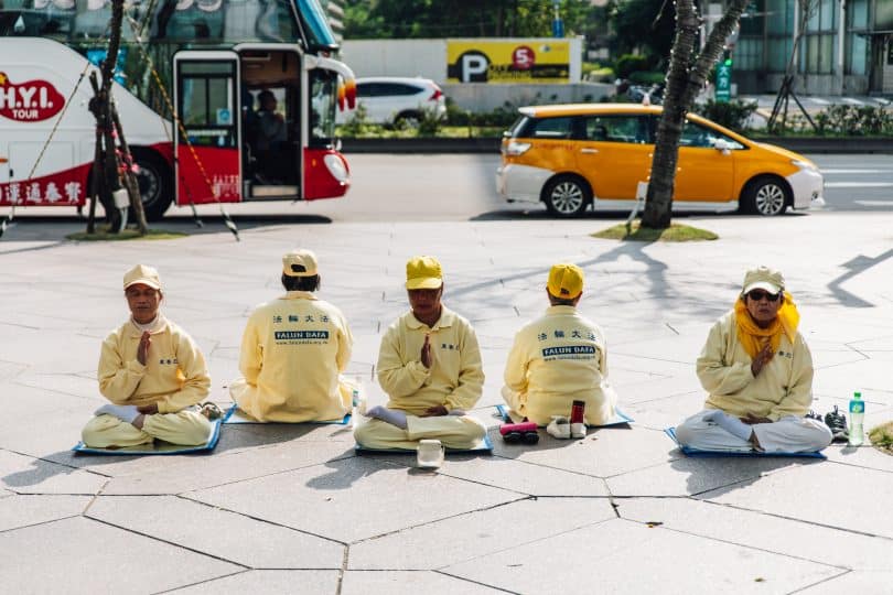 Pessoas do movimento Falung Gong sentados em meditação.