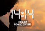 Hora igual 14:14 e texto "Hora da benção divina!" aplicado por cima de foto da silhueta de uma mulher de lado com a cabeça inclinada para baixo e as mãos juntas, sinalizando uma oração. Ao fundo, há um céu claro com nuvens alaranjadas pela luz do pôr do sol.