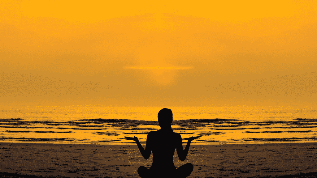 silhueta de pessoa meditando na praia