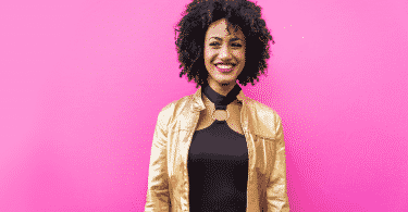 Mulher sorrindo para a câmera em um fundo rosa