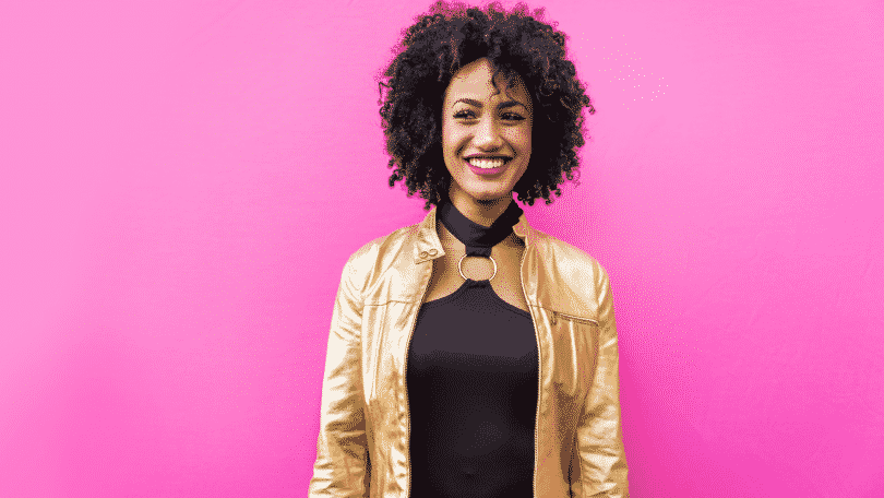 Mulher sorrindo para a câmera em um fundo rosa