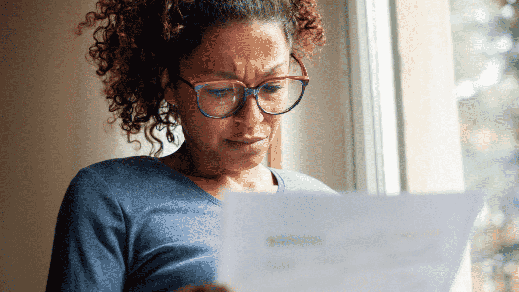 Mulher com expressão tensa lendo uma notícia